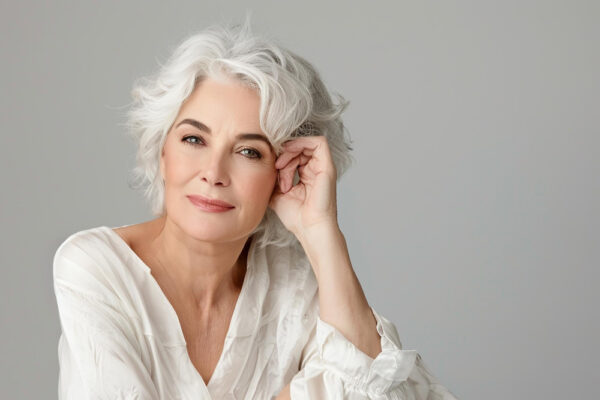 Hübsche authentische Frau mit grauen Haaren als Symbolbild für den Ratgeber: Graue Haare nicht mehr färben